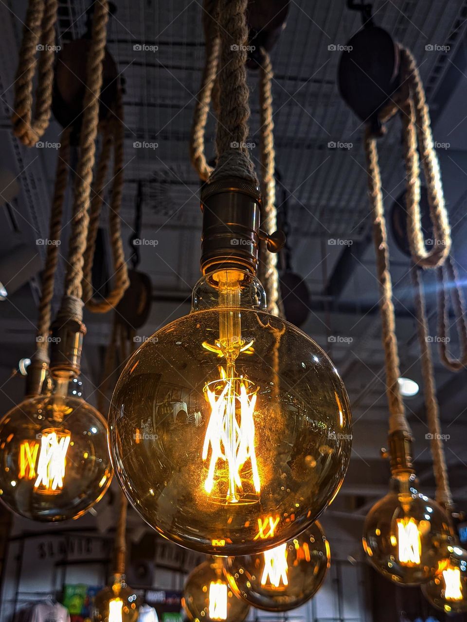 All sorts of yellow lamps under the ceiling in the store.