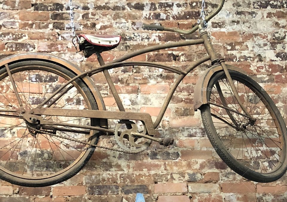 Vey old bicycle against an old brick wall