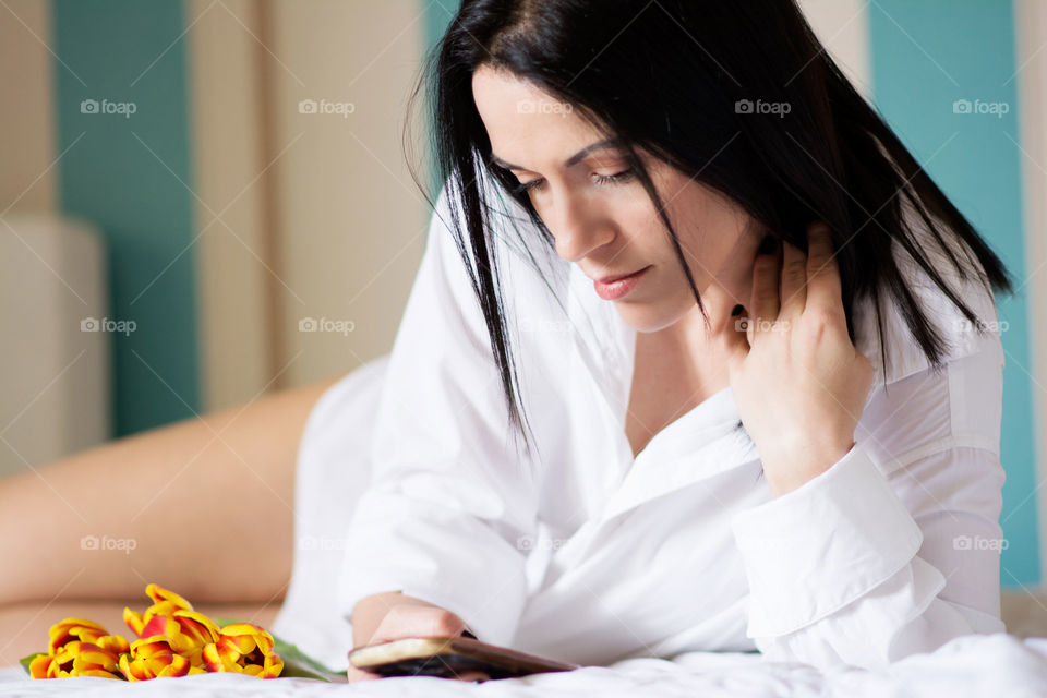 Black haired woman typing on the phone