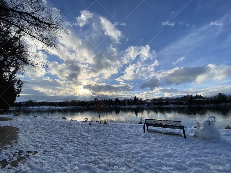 About to enjoy the scenic winter landscape while sitting on a bench at the lake. 