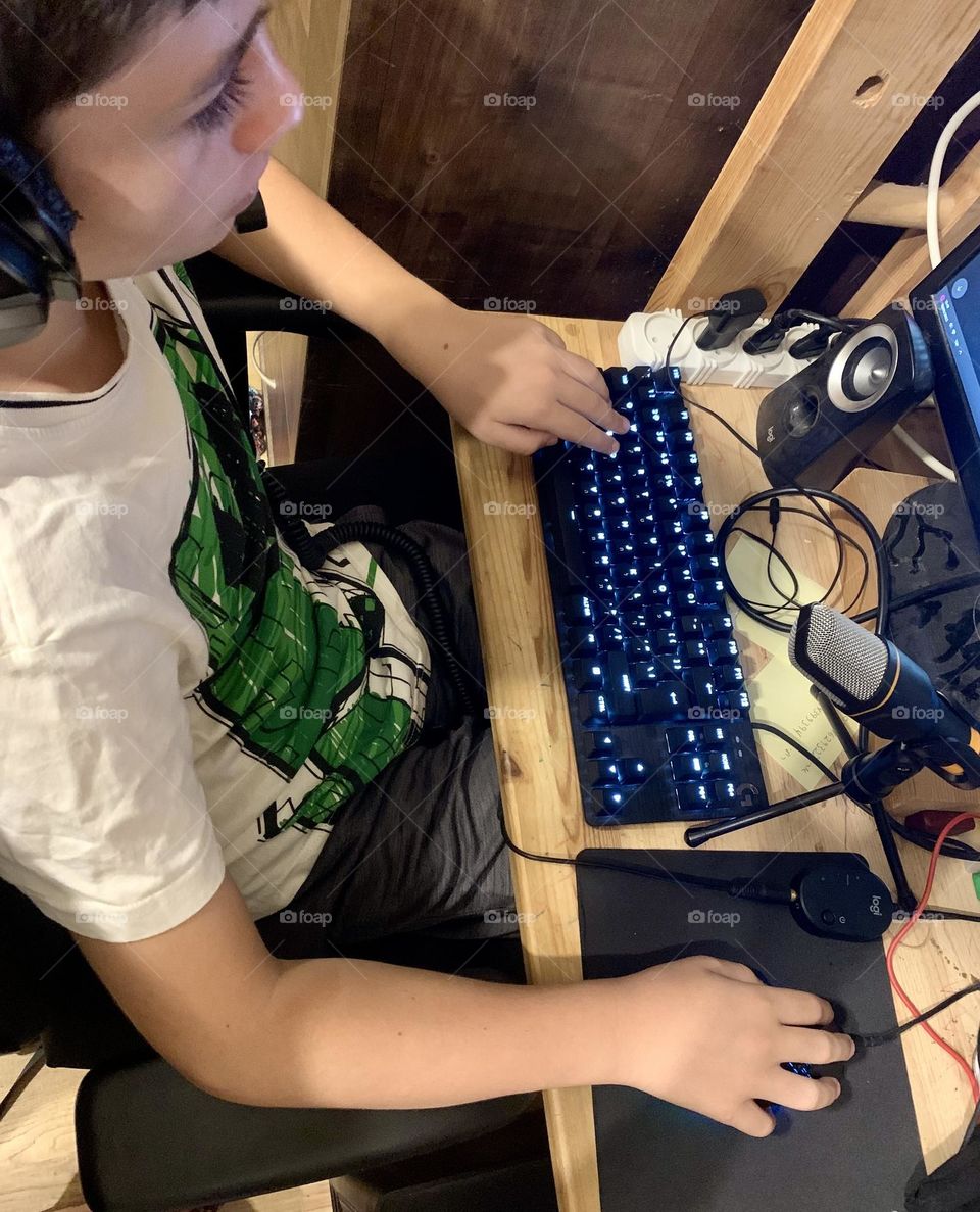 Kid with Minecraft shirt playing in the computer 