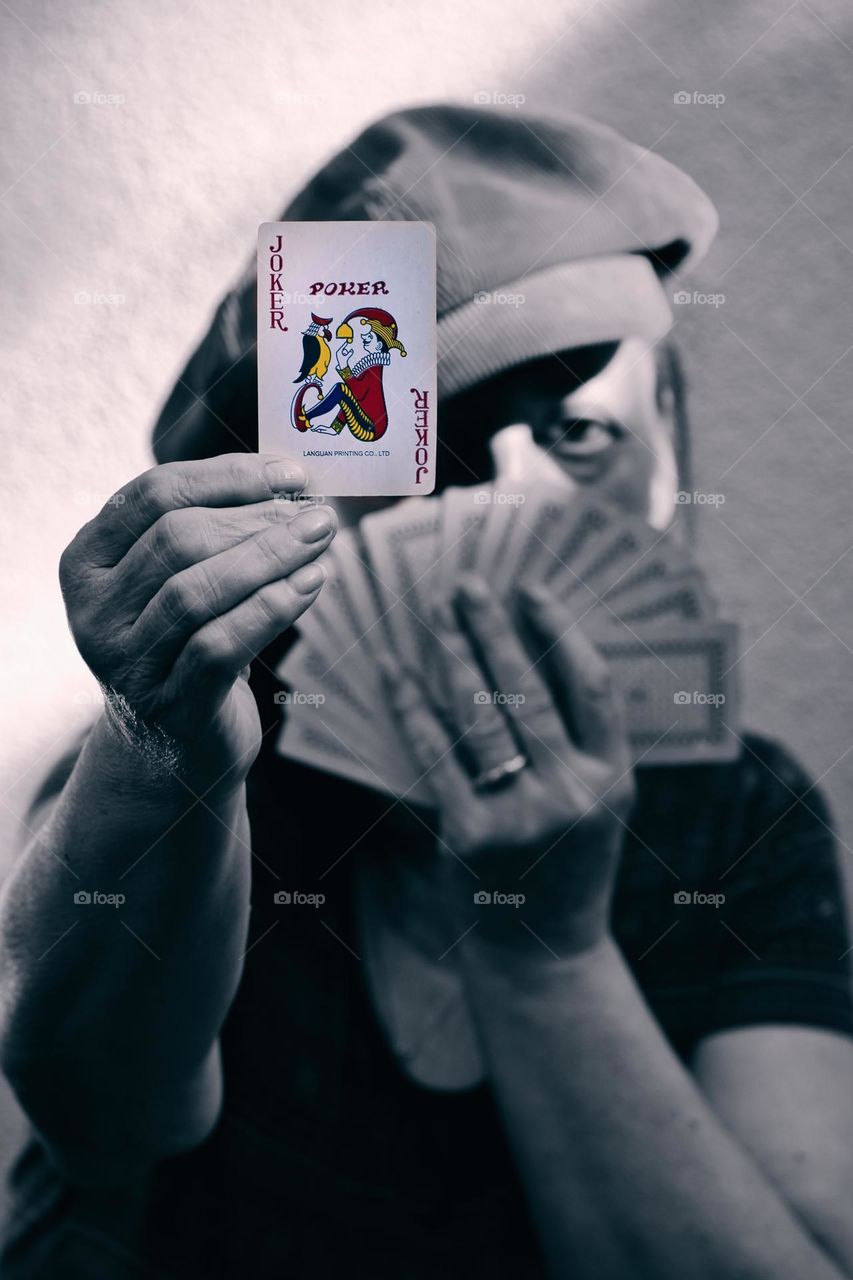 Woman holding cards with joker card in front