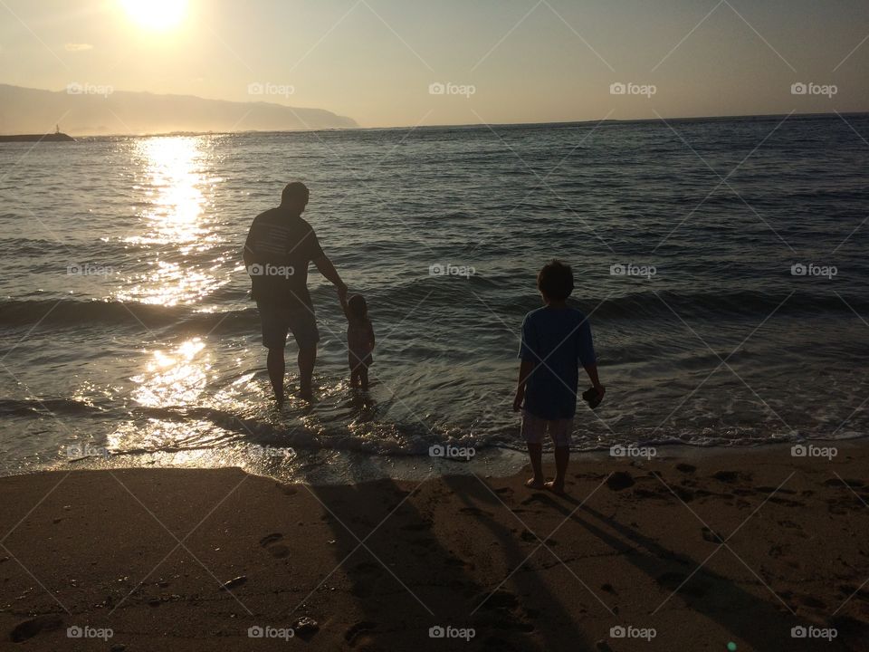 Dad and kids enjoying a Hawaiian sunset