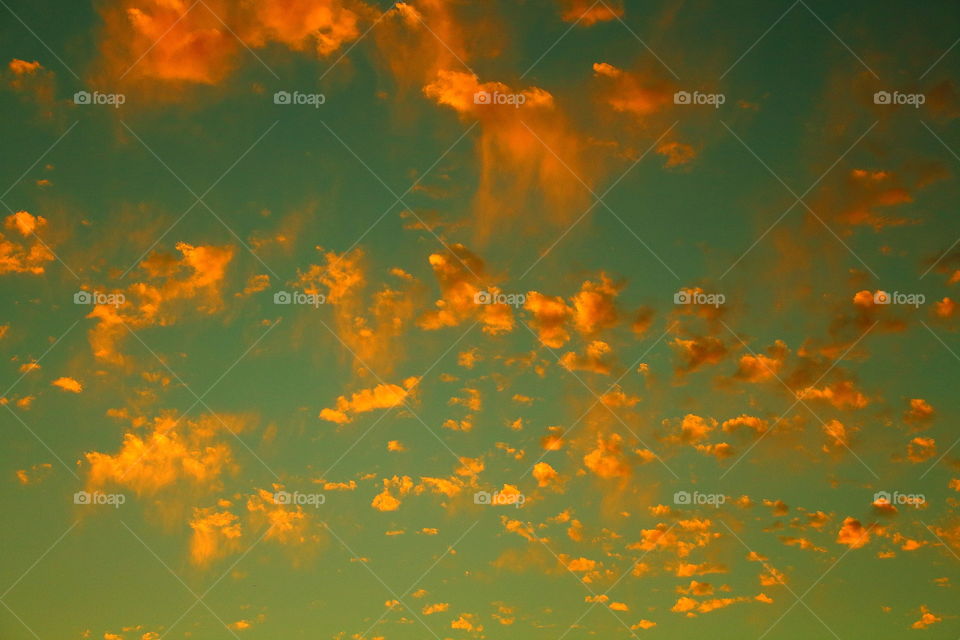 sunset sky. golden clouds with sun reflection 