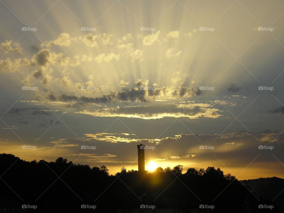 Silhouette of trees and lighthouse during sunrise