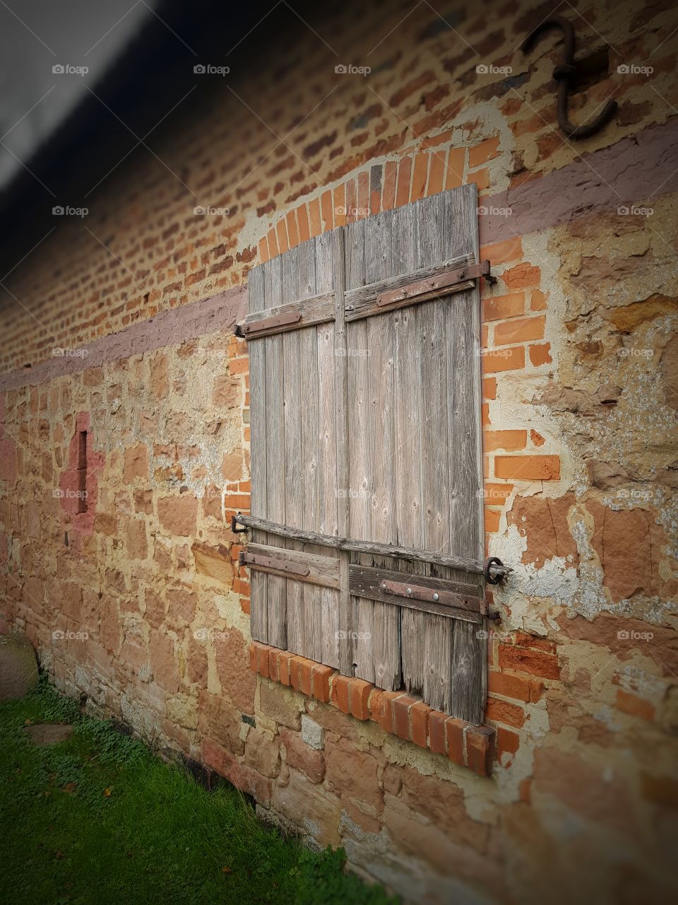 Old wooden window in sandstone wall