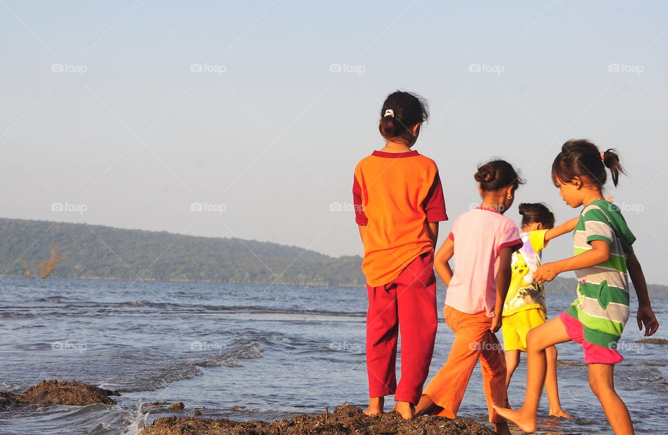 Enjoy the wave of the beach with others. One group of teenagers completely play, to walk at side of the beach. So calm, and harmony.