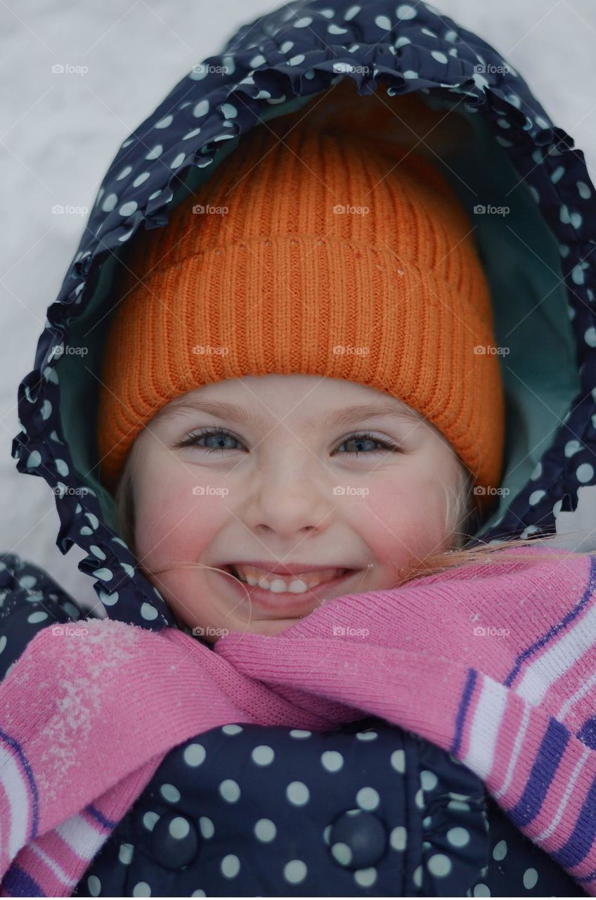 girl laying in the snow and smiling