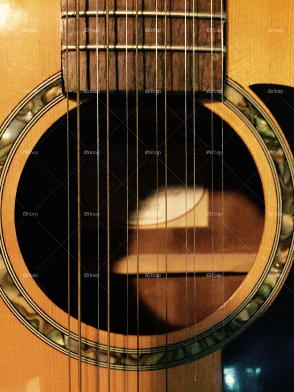 Closeup of a 12 string guitar looking into the hollowed out part..