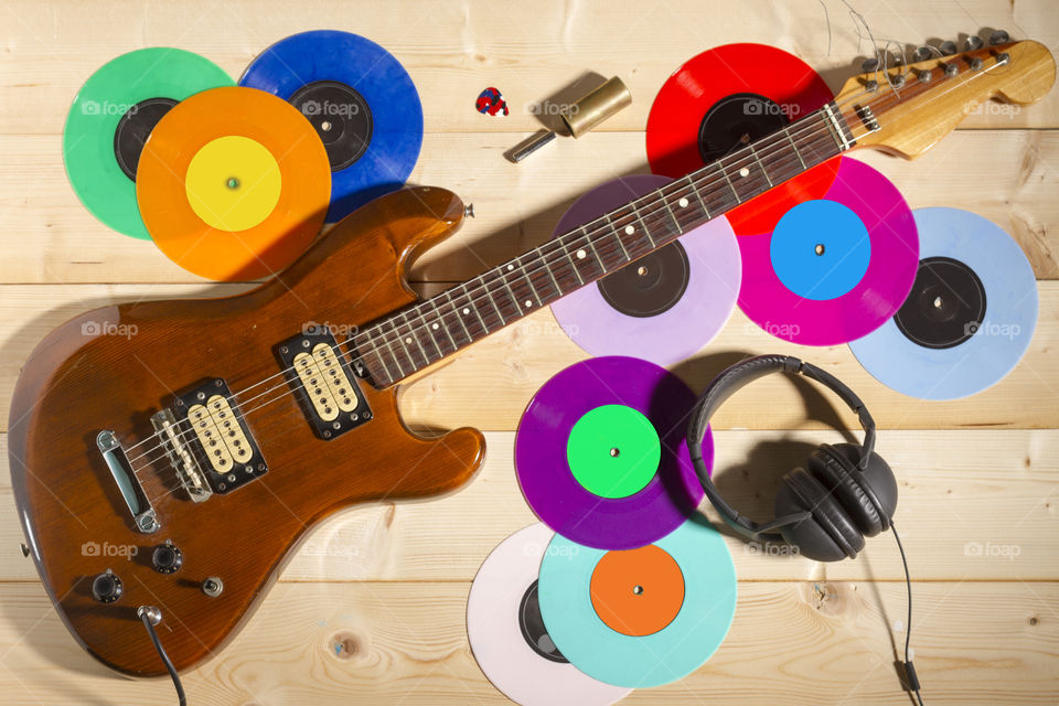 Electric guitar and vinyl records. Electric guitar, vinyl records and headphones on wooden background