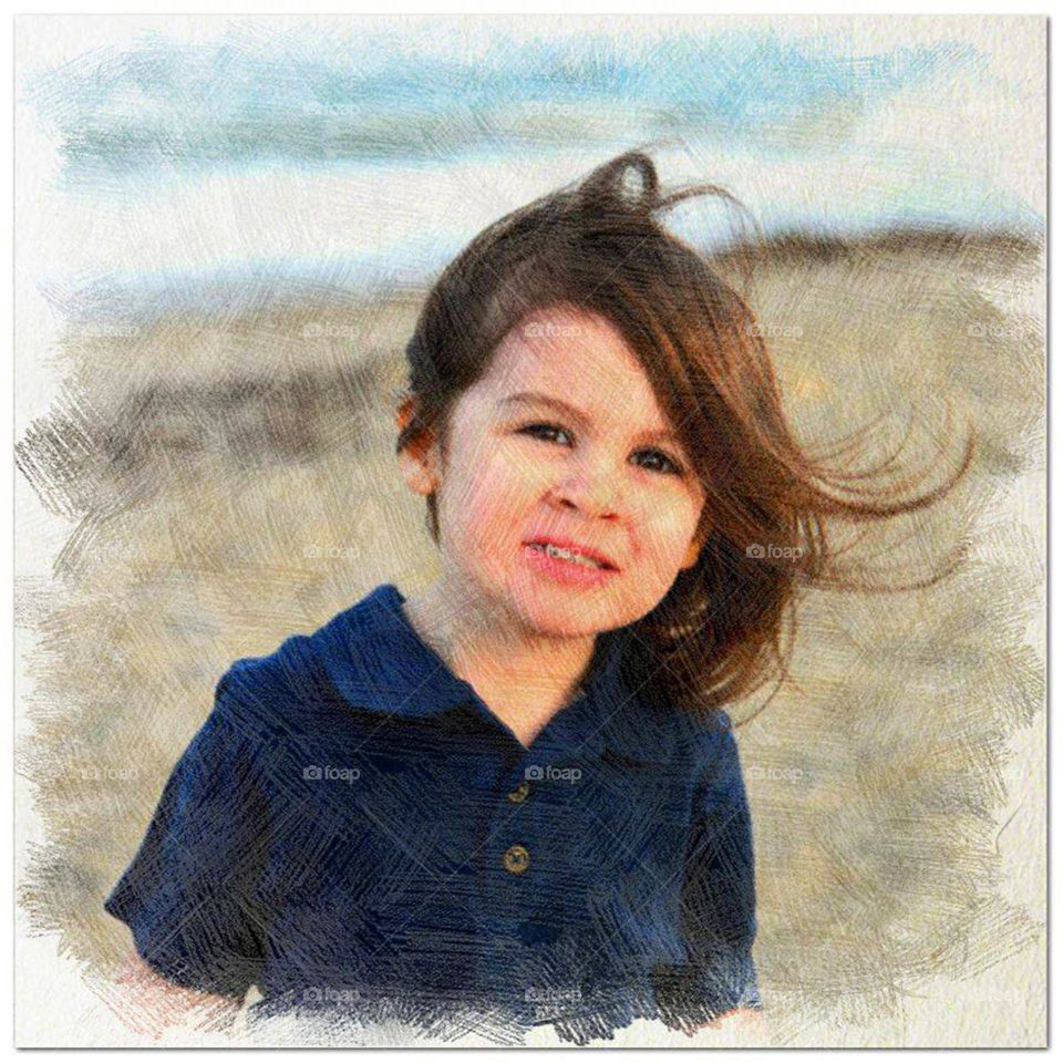 portrait. Toddler on the beach with wind blown hair