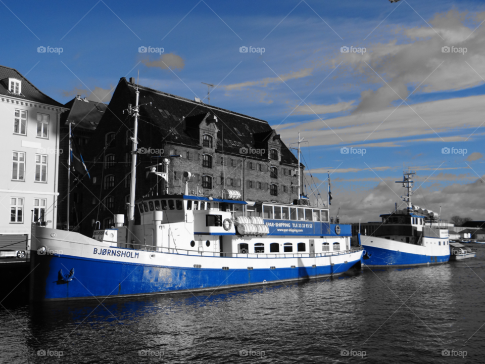 Bjornsholm boat in nyhaven . Blue boats in Nyhaven  denmark  black and whitebwith blueb highlight 