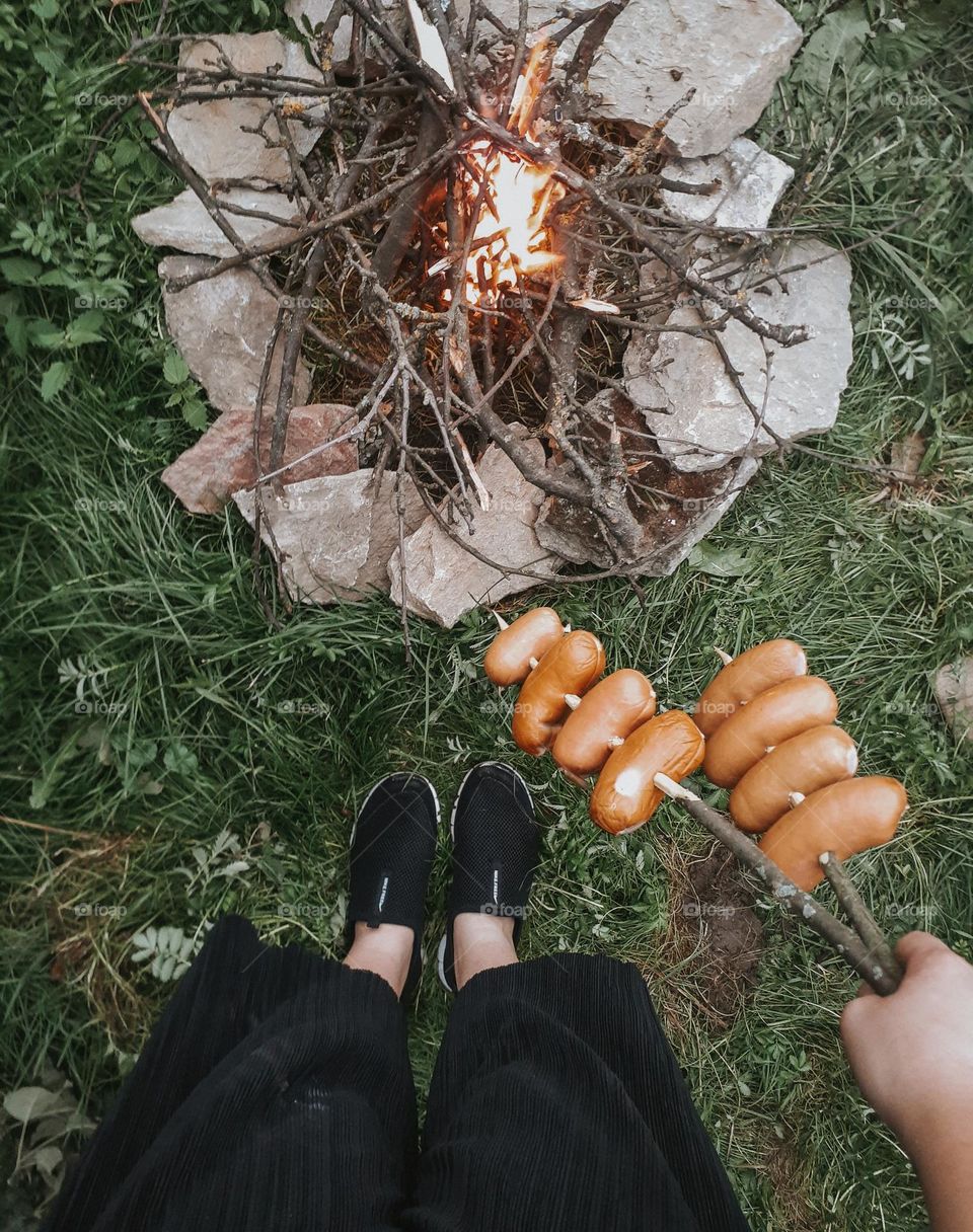 Frying sausages on an open fire in a city park