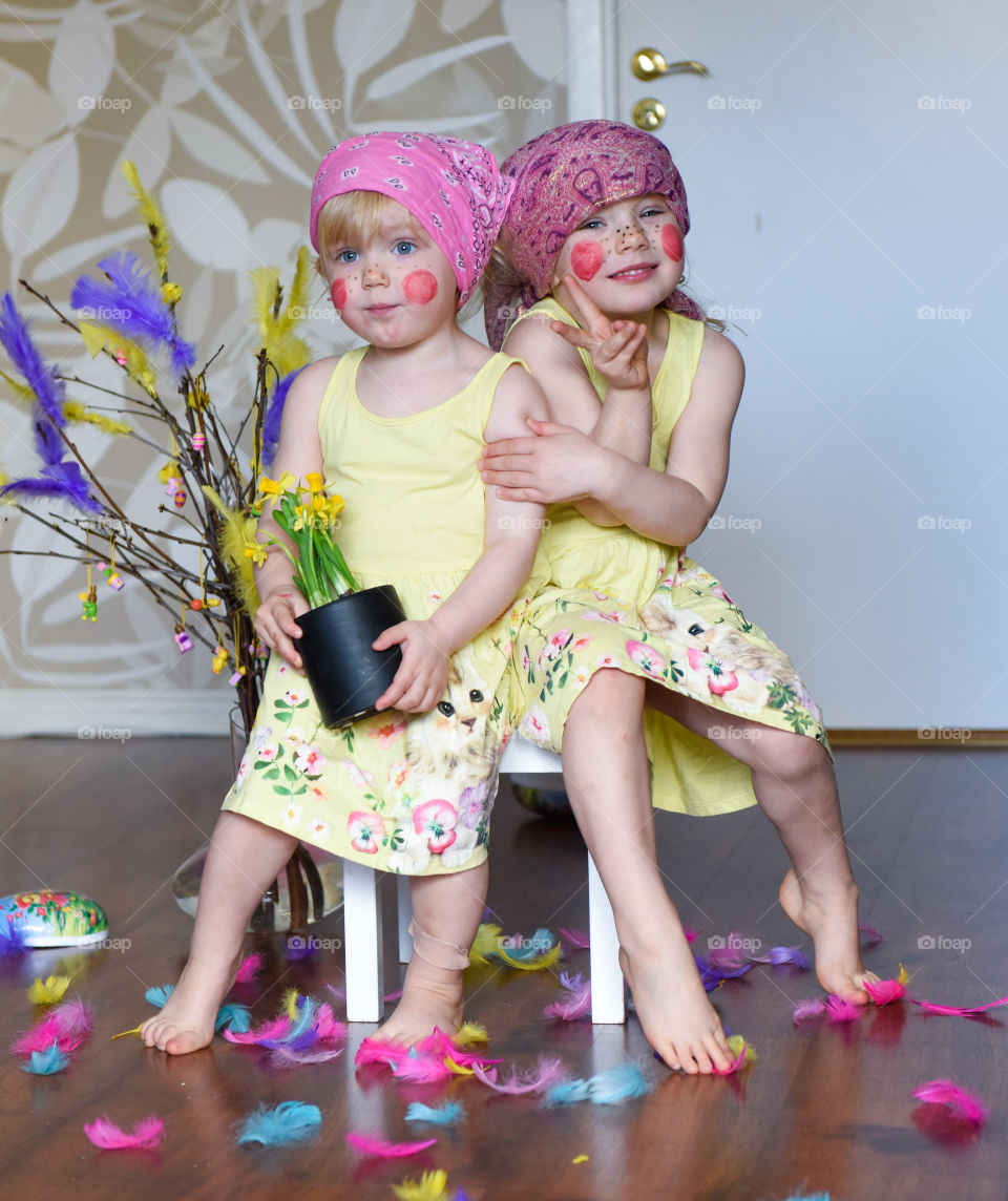 Two young sisters having fun infront of the camera with easter theme.