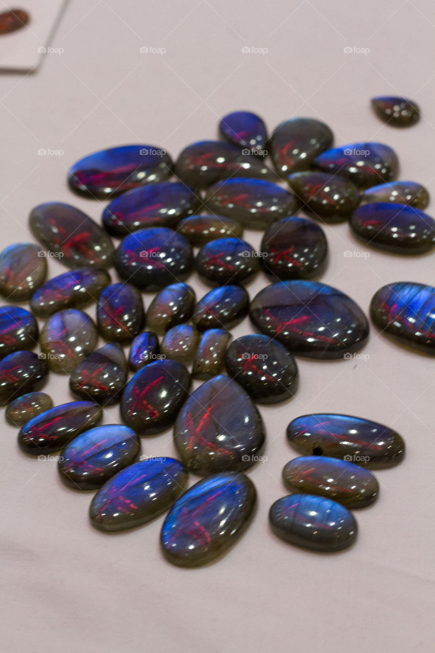 Semi precious gem stones reflecting an x shaped light fixture above