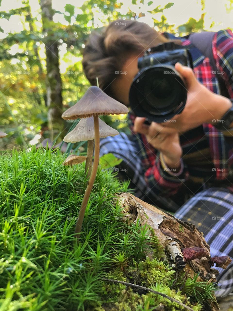 Ground up photo of the woman with photo camera.  Backstage of the photoshoot.  Natural park. Natural background