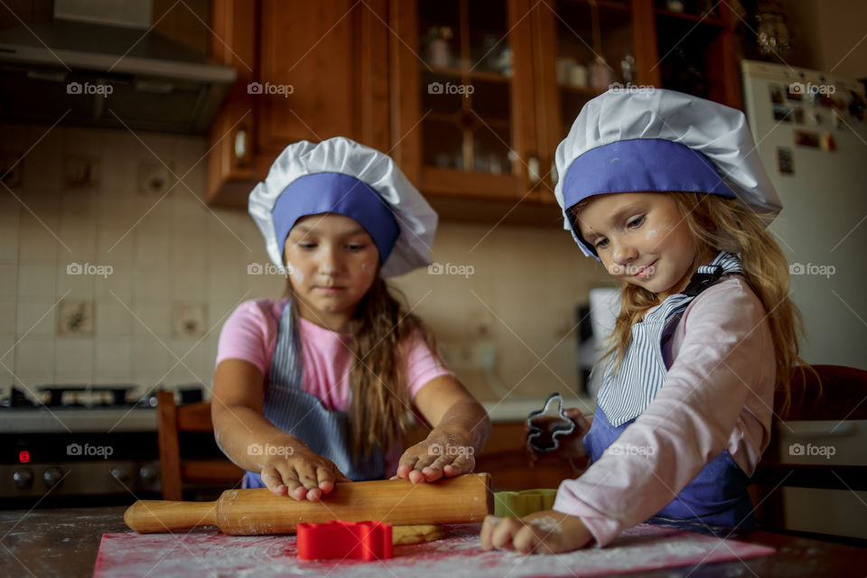 Little sisters cooking the biscuits 