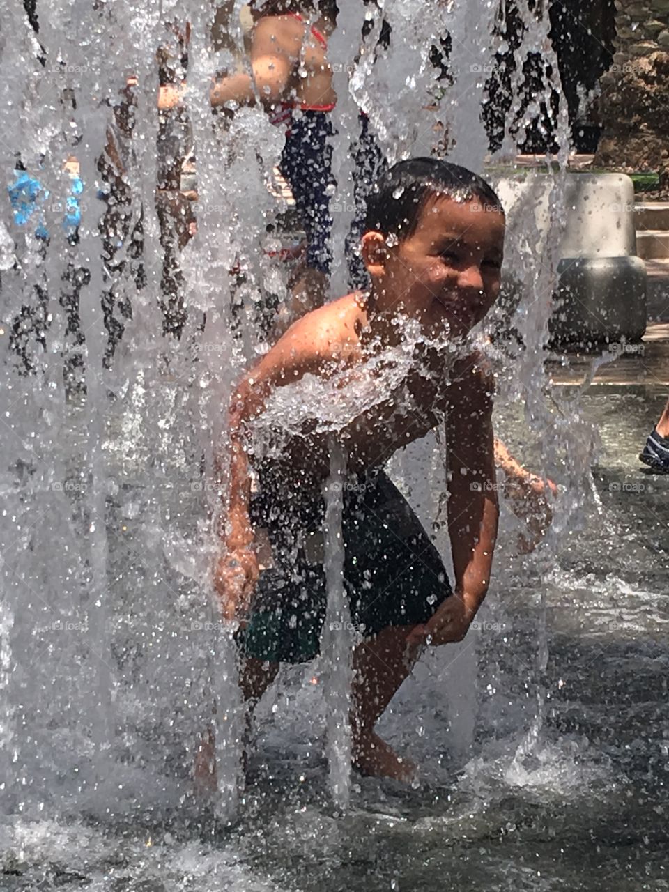 Boy playing in a splash pad.