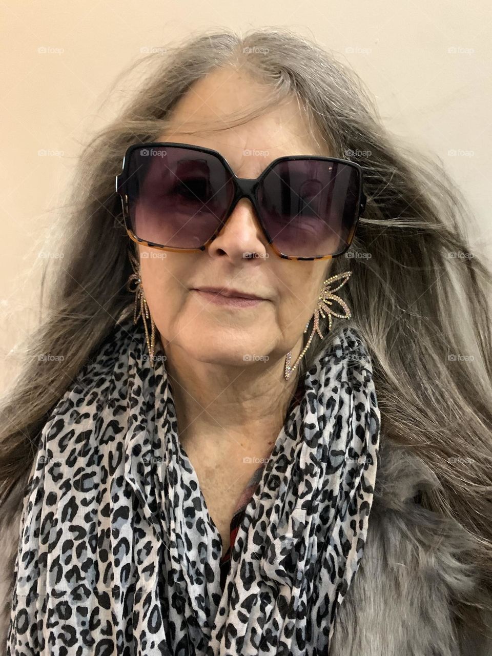 Stylish senior woman in sunglasses and statement earrings 