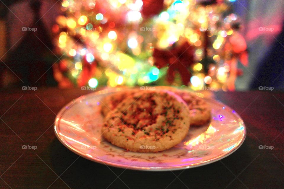 Christmas cookies on a plate by a Christmas tree