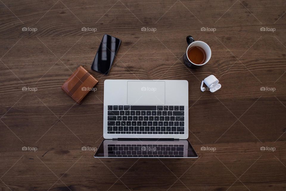 Modern essentials are arranged on a wooden table.