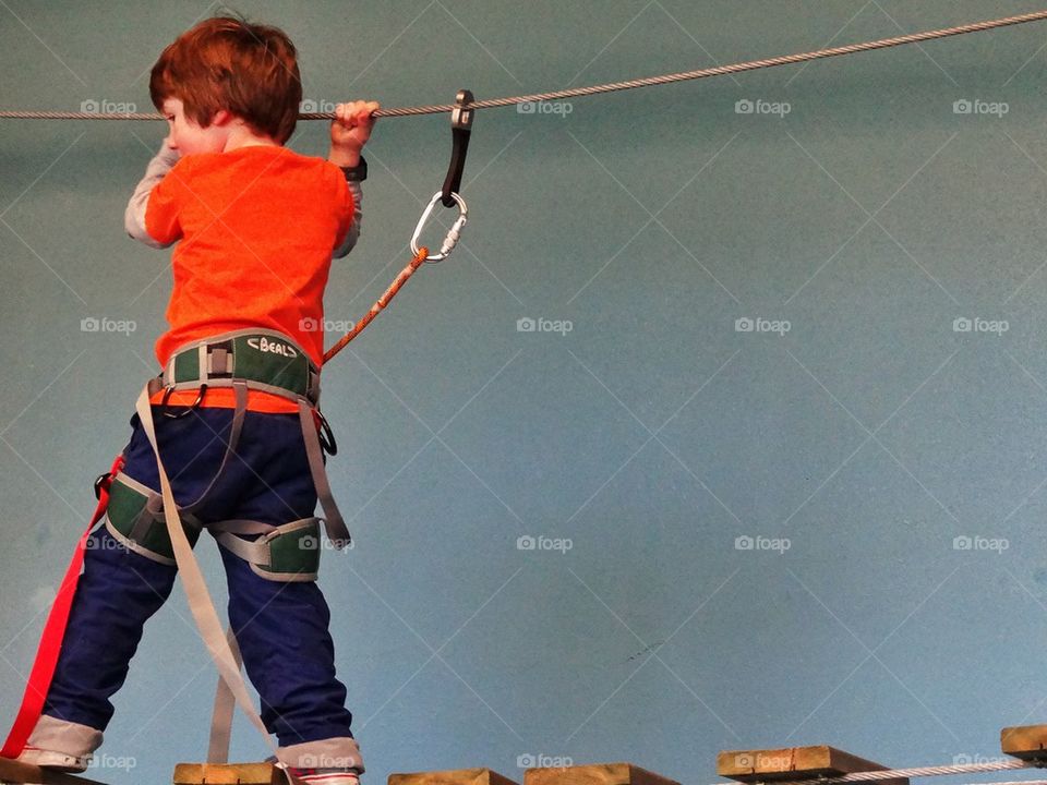 Confidence. Boy Traversing A Rope Bridge