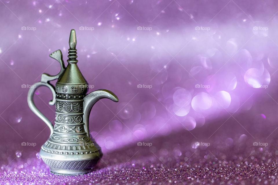 Arabic coffee pot with purple bokeh background and light