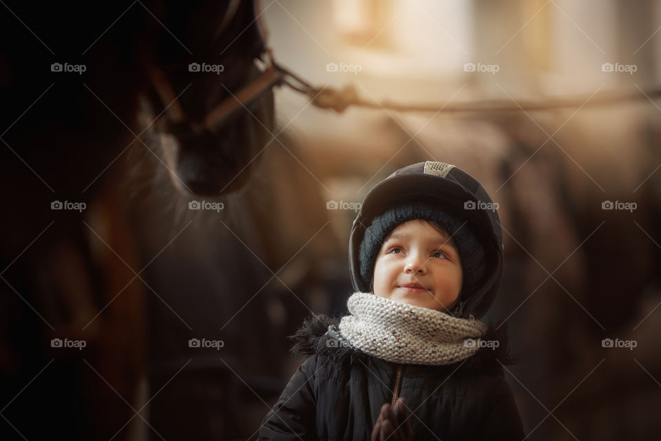 Girl in horse riding wear in a stable