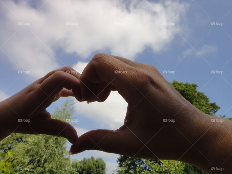 mother and child's hands together forming a love heart.