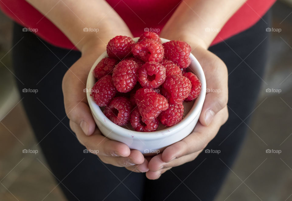 Holding a bowl of raspberries 