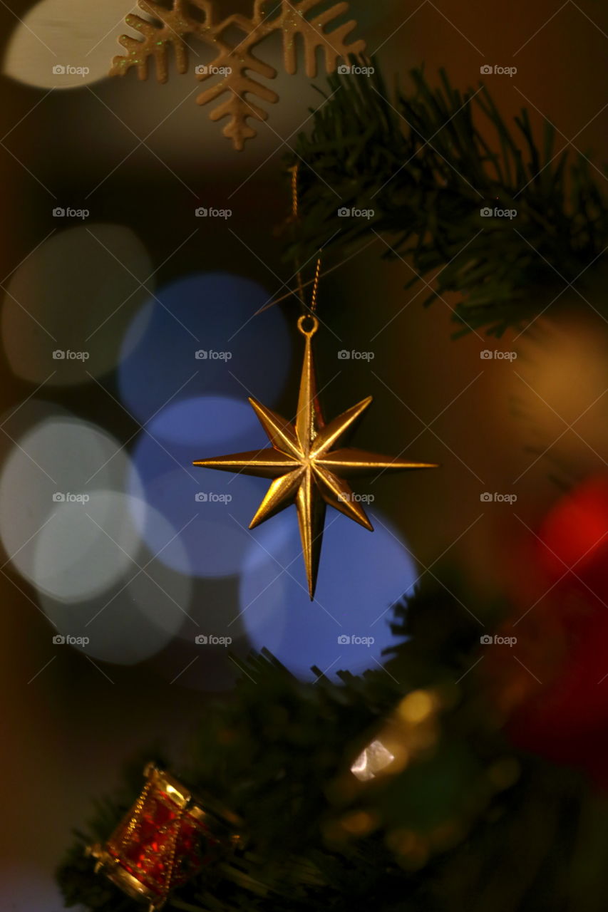 star hang on Christmas tree with a blurry background