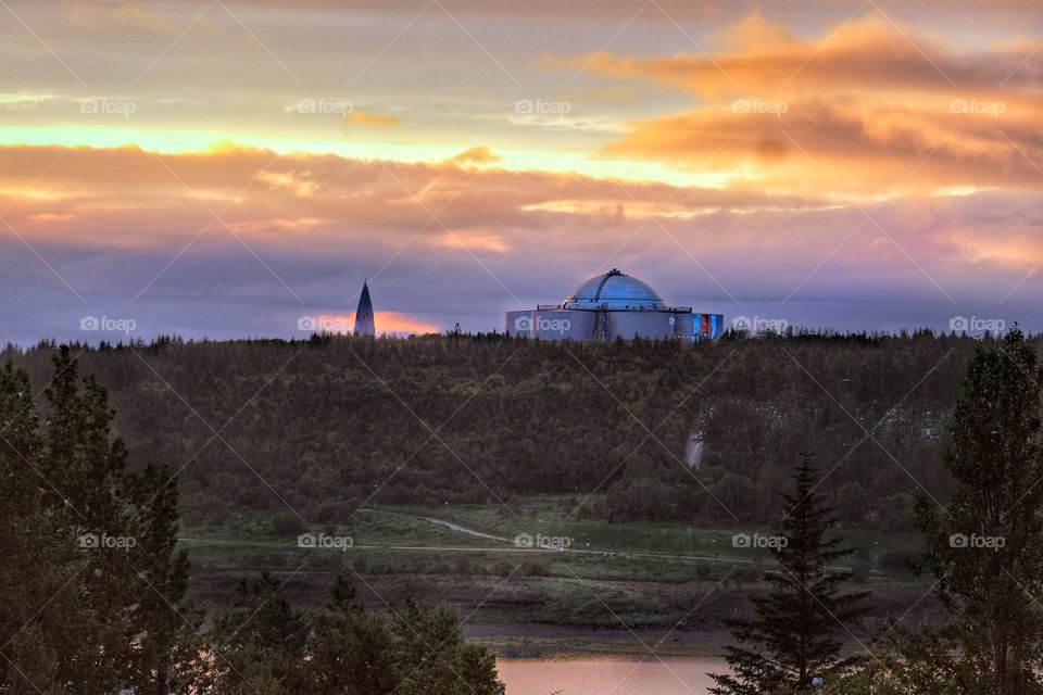 At the setting of the midnight sun, I came across this view.  Taken at one church in a town called Kopavogur facing another famous church in Iceland called Hallgrimskikjur.  The steeple visible in the distance.