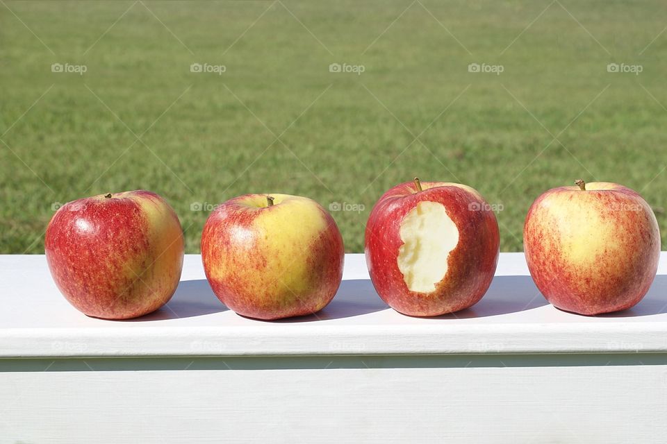 Apples in a line a bite out of one