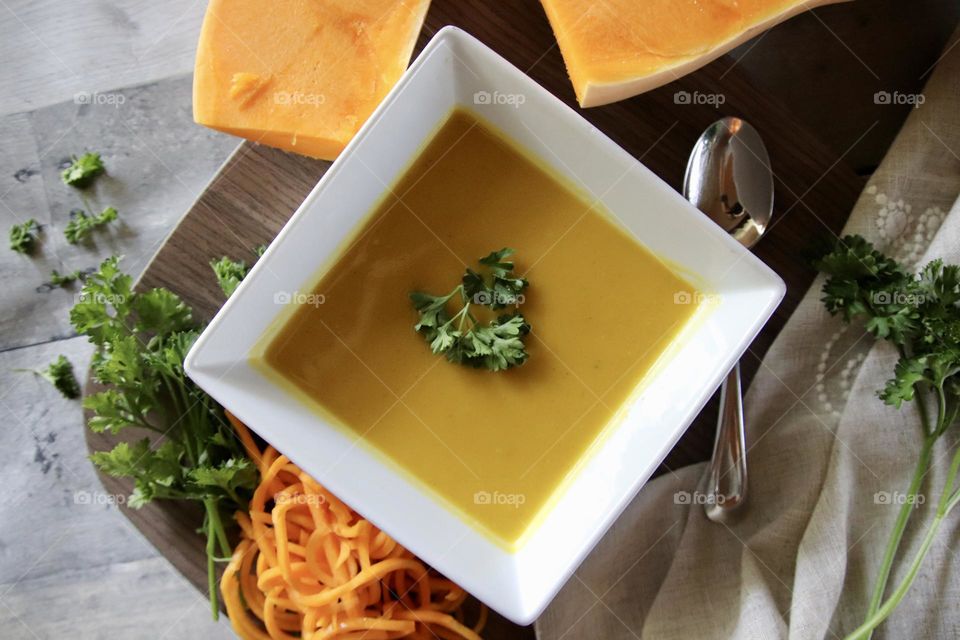 Flat lay of butternut squash soup square bowl