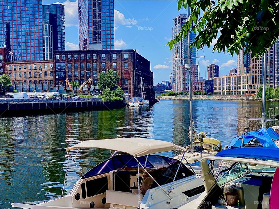 The nuances of the sunlight here at „Newtown Creek“ in LIC are just perfect today. The trees by the shore reflect in the still waters of the „East River“ and the sunlight refracts off the top sending off bursts of light. 2023. Hypnotic Productions