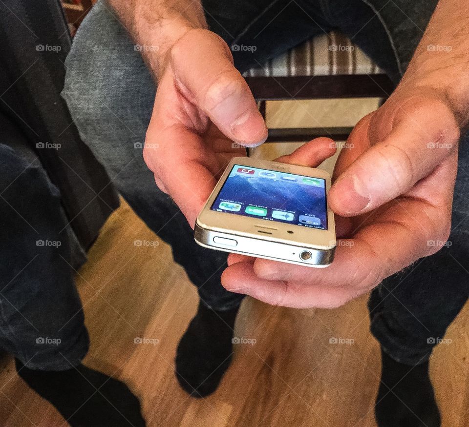 Person closeup holding an iPhone in his hands