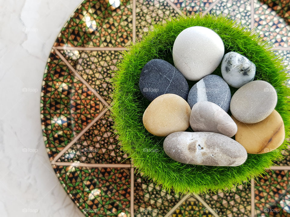 colourful pebbles on a grass vase on a beautiful plate