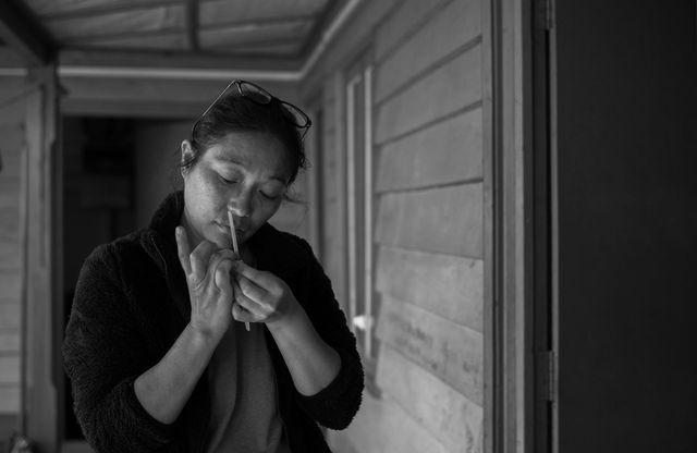 A black and white picture of a lady doing her nails.