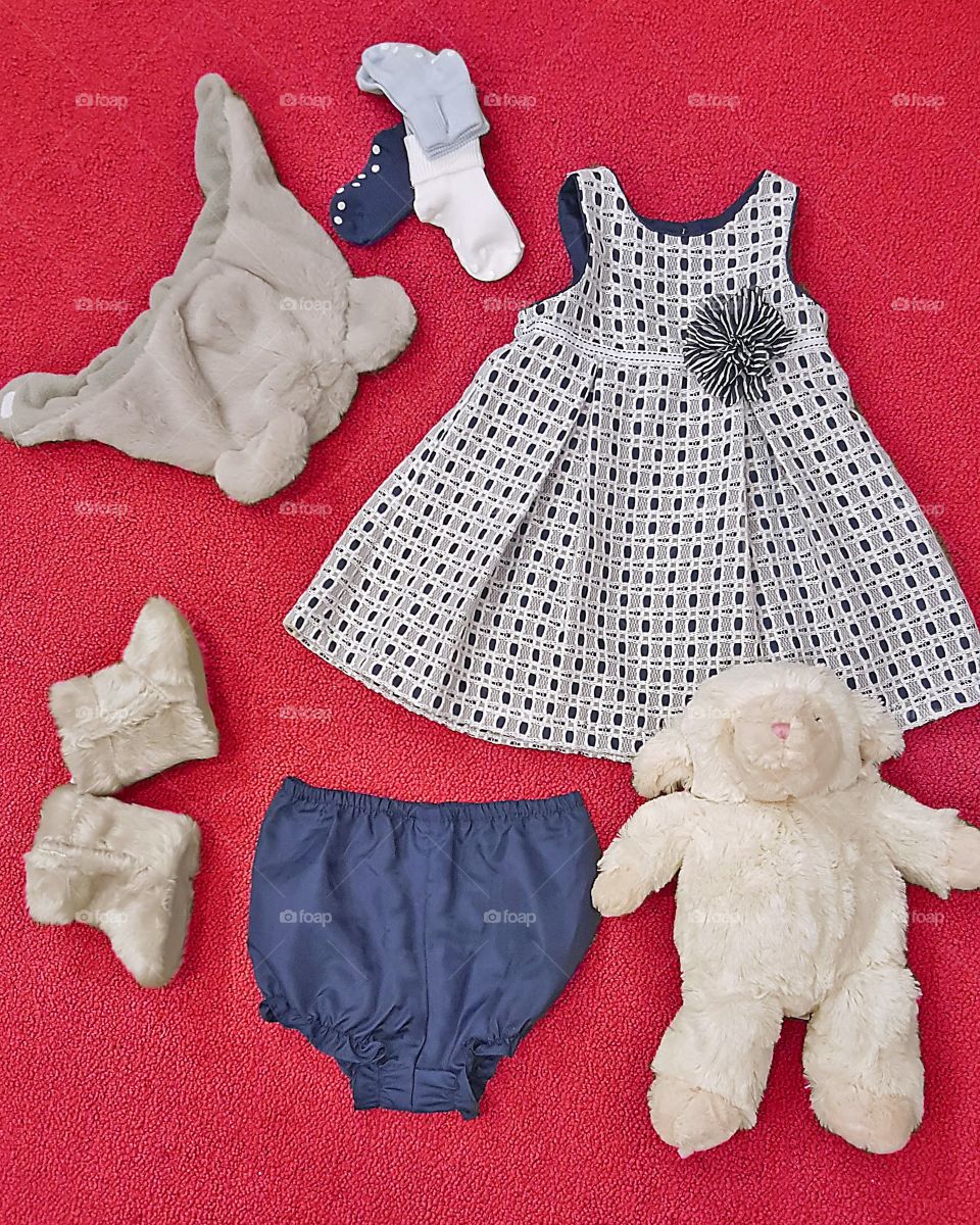 baby girl fashion flat lay/ layout featuring a sporting dress and fuzzy accessories