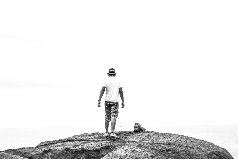 Rear view hiker standing on rocky mountain