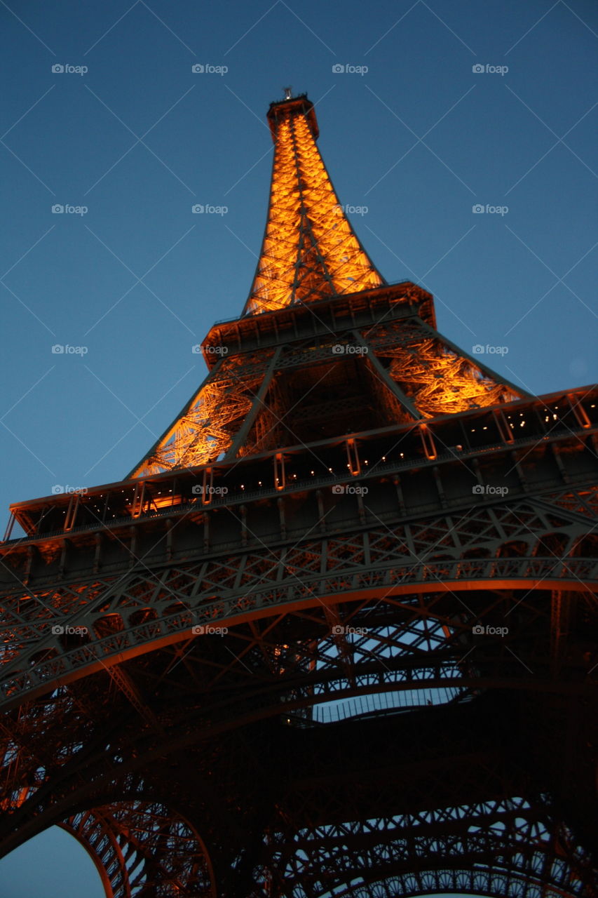 View from below the Eiffel tower in Paris by night