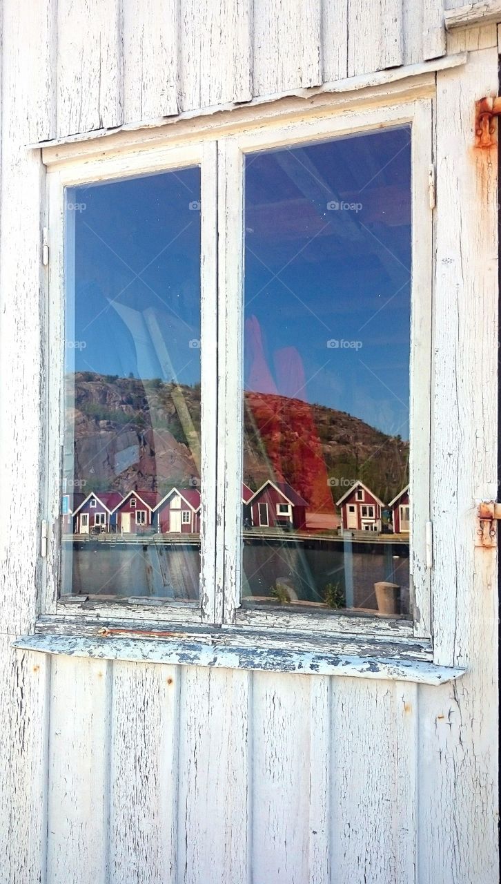 boathouses on a row reflected in a window