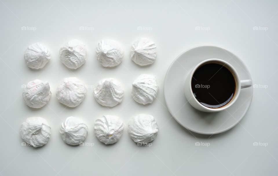 cup of coffee with sugar meringues sweets top view on a white background