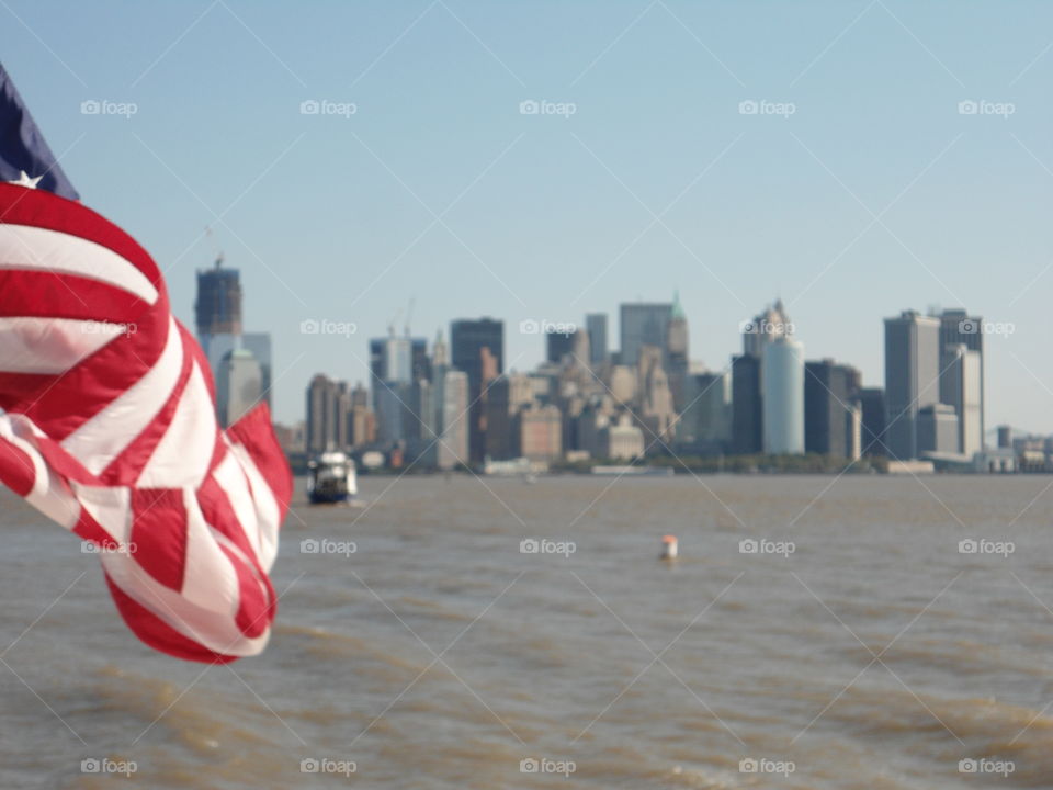 View from a ferry to Manhattan south with a American flag 