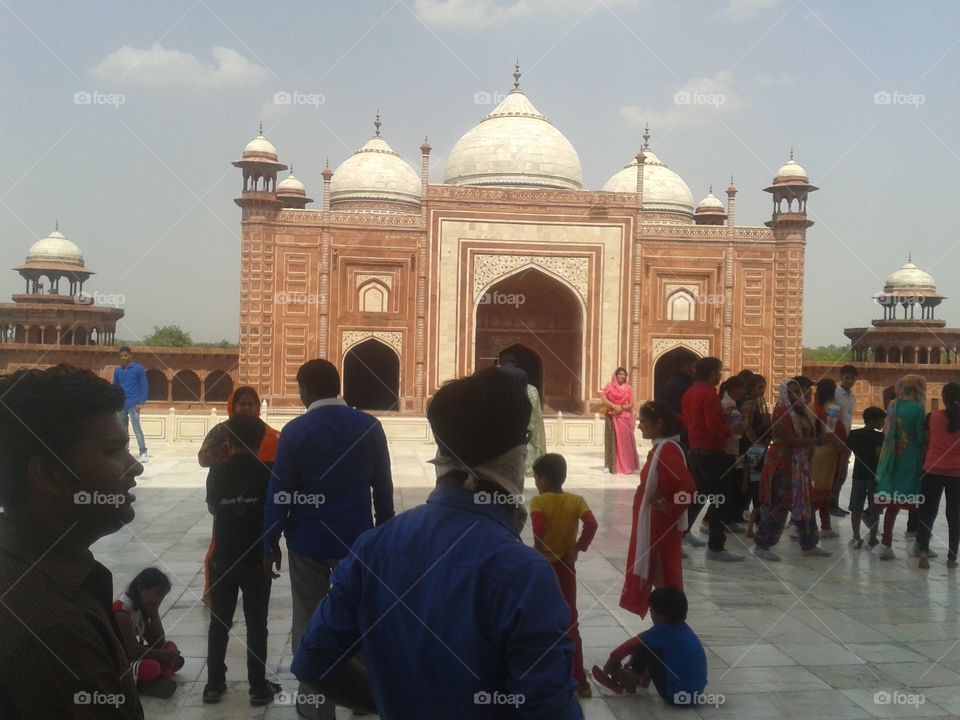 The Taj Mahal (/ˌtɑːdʒ məˈhɑːl, ˌtɑːʒ-/;[3] meaning Crown of the Palace[4]) is an ivory-white marble mausoleum on the south bank of the Yamuna river in the Indian city of Agra. It was commissioned in 1632 by the Mughal emperor, Shah Jahan (reigned from 1628 to 1658), to house the tomb of his favourite wife, Mumtaz Mahal. The tomb is the centrepiece of a 17-hectare (42-acre)[5] complex, which includes a mosque and a guest house, and is set in formal gardens bounded on three sides by a crenellated wall.