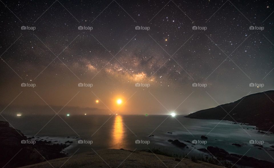 The up rising Moon at the beach along with Milky Way and Beautiful Stars 