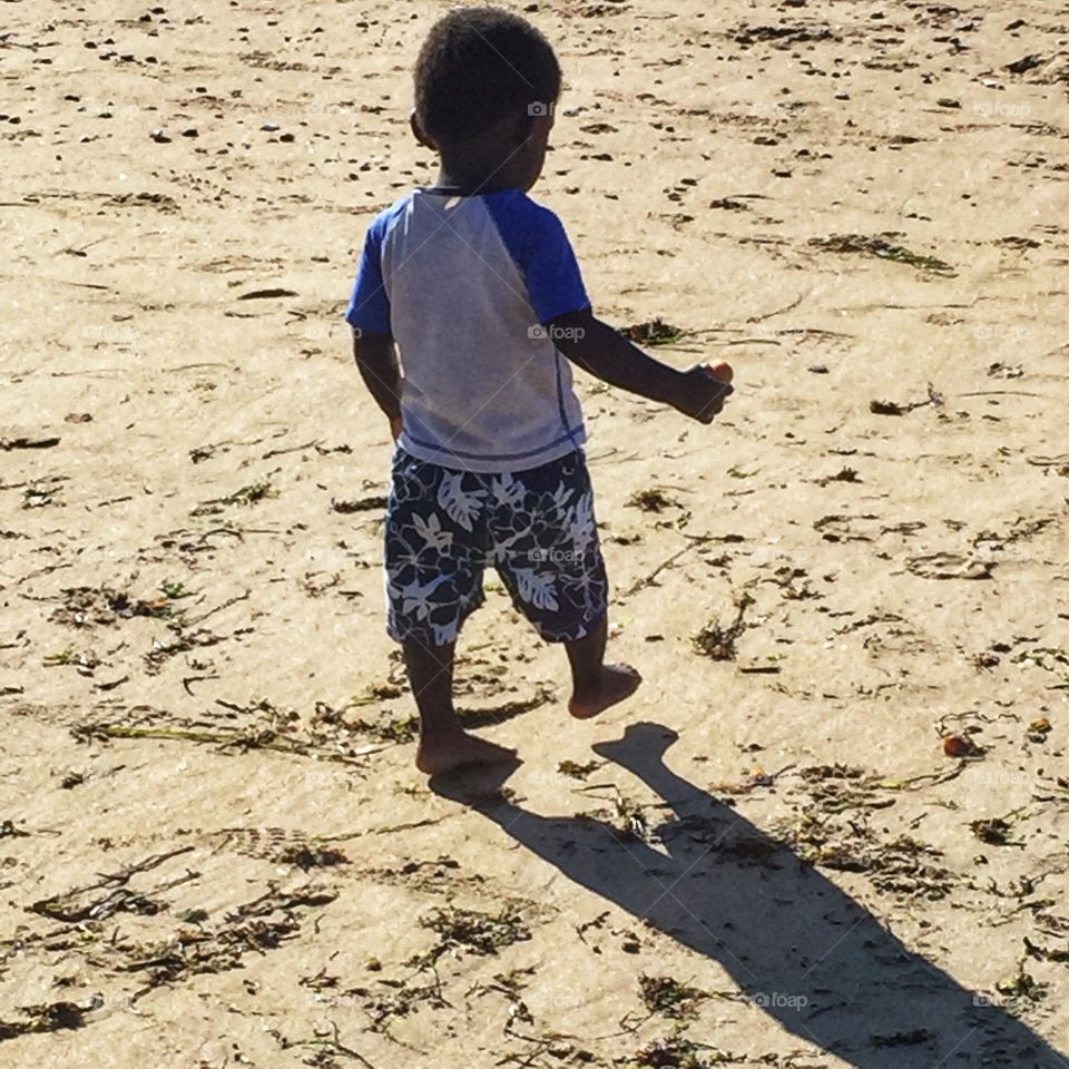 Boy on beach with shadow
