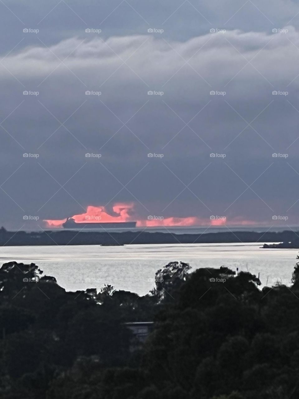 Sunrise on the ocean looks like the ship is on fire 