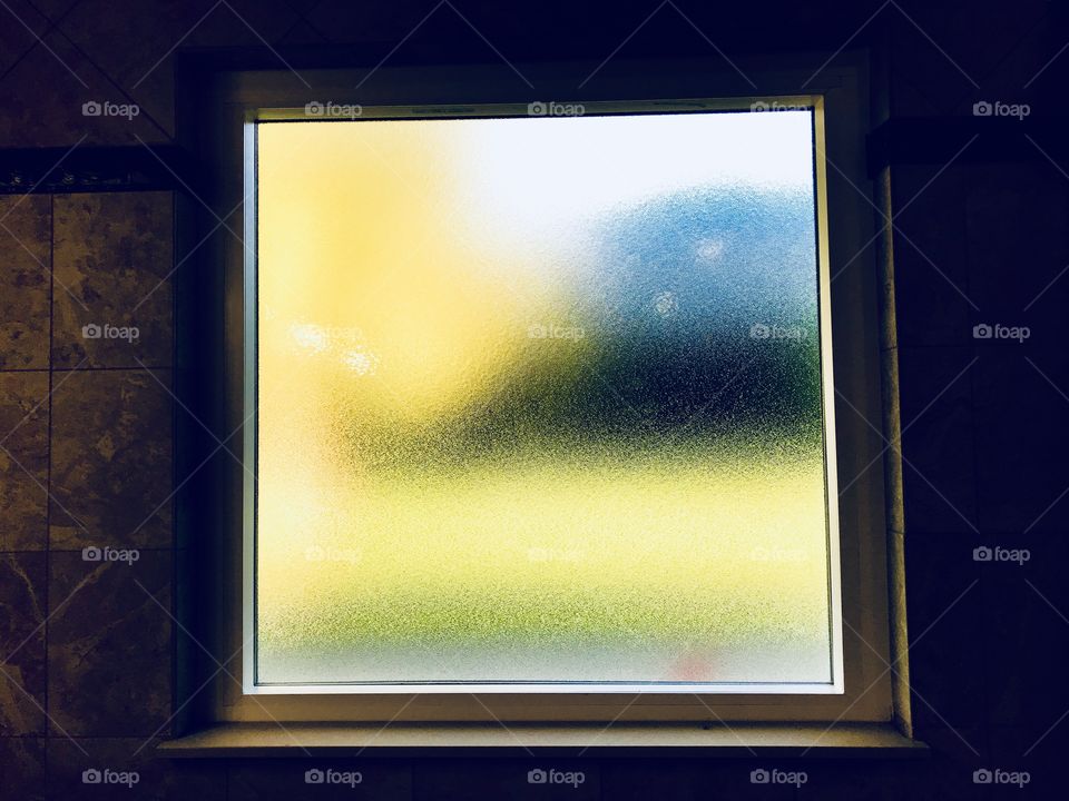 The reflections of the outdoor light give colors to the window inside. 