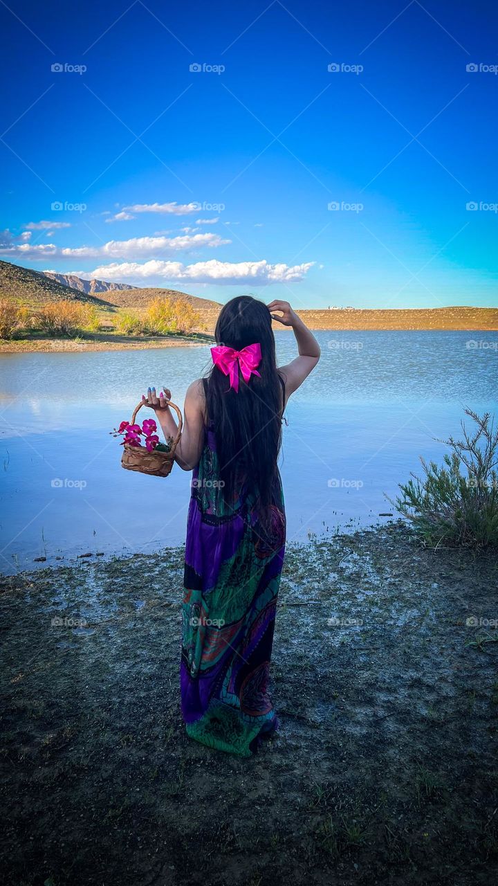 girl in nature with basket of flowers